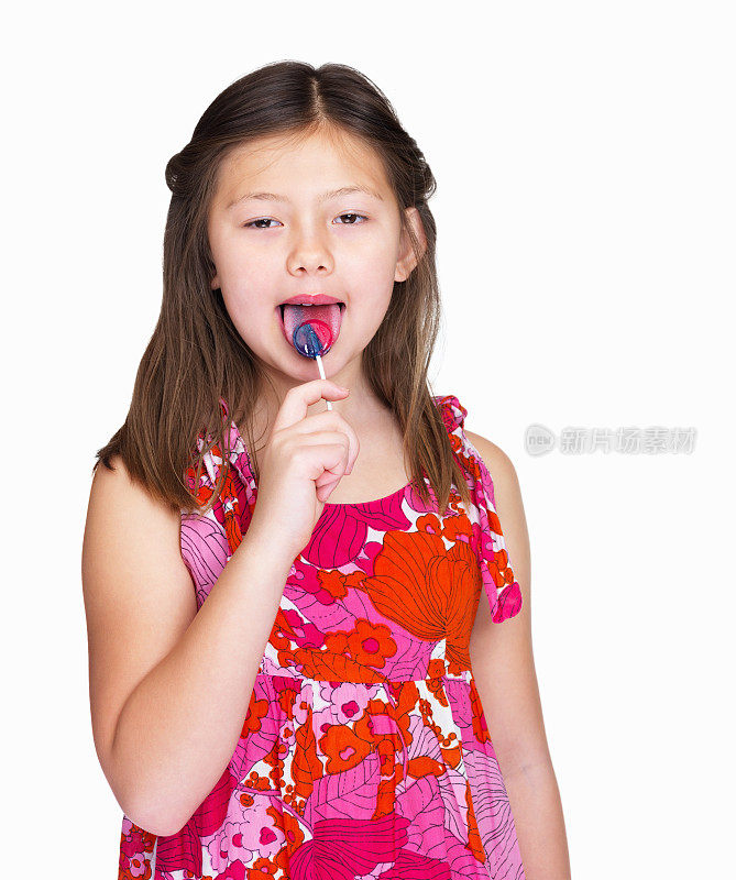 快乐的小女孩舔着白色的棒棒糖