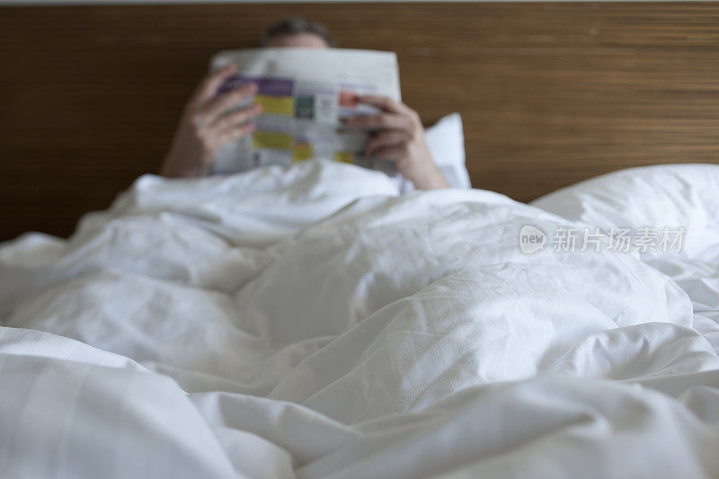 男人在床上看报纸