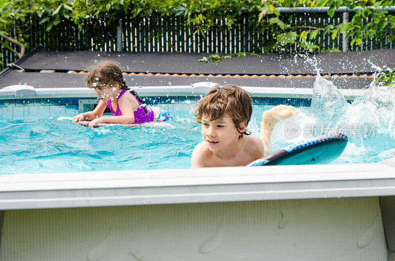 两个孩子在后院的游泳池里玩