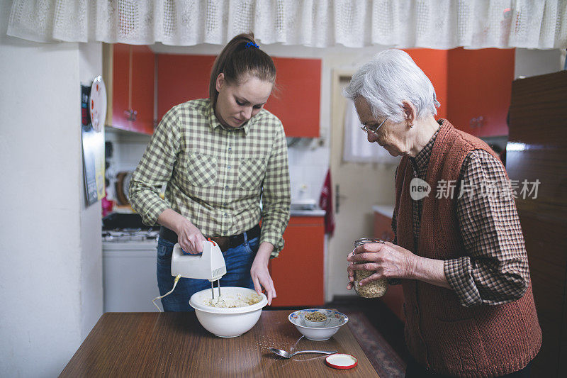 祖母和孙女烘烤饼干准备面团