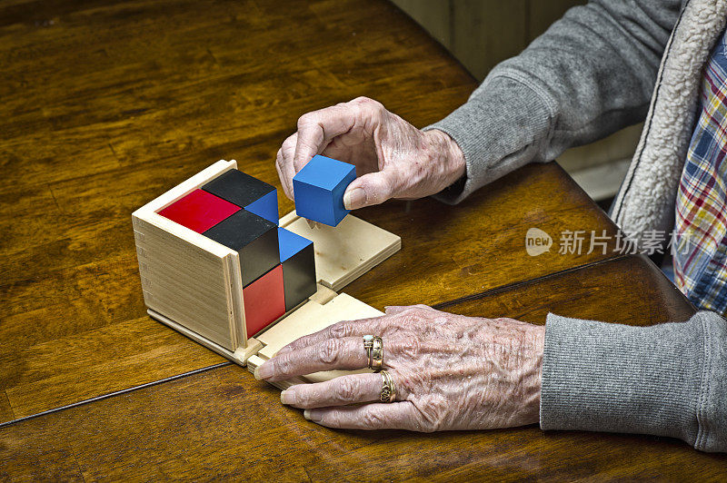 老年女性痴呆症患者在玩拼图。