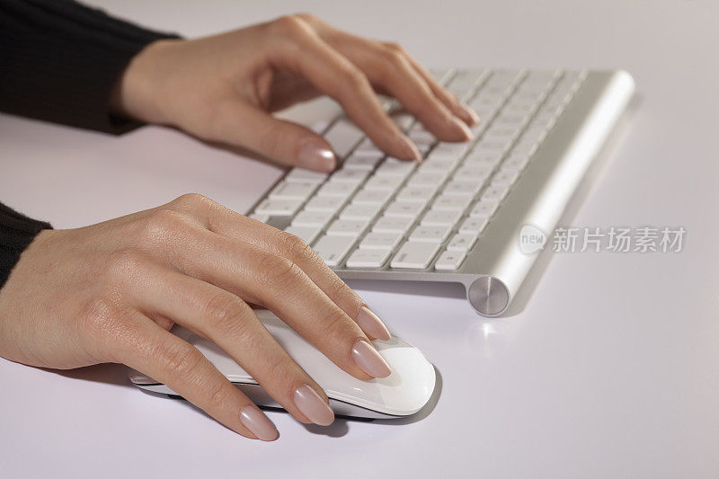 手打字与干净的白色无线电脑键盘和鼠标