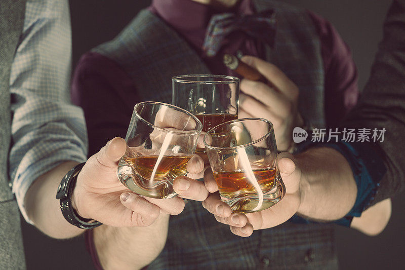 男人们喝着威士忌，靠近杯子和手