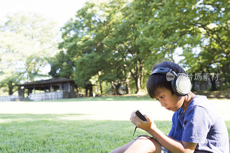 男孩在用智能手机听音乐