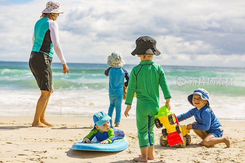 母亲和男孩在海滩上防晒