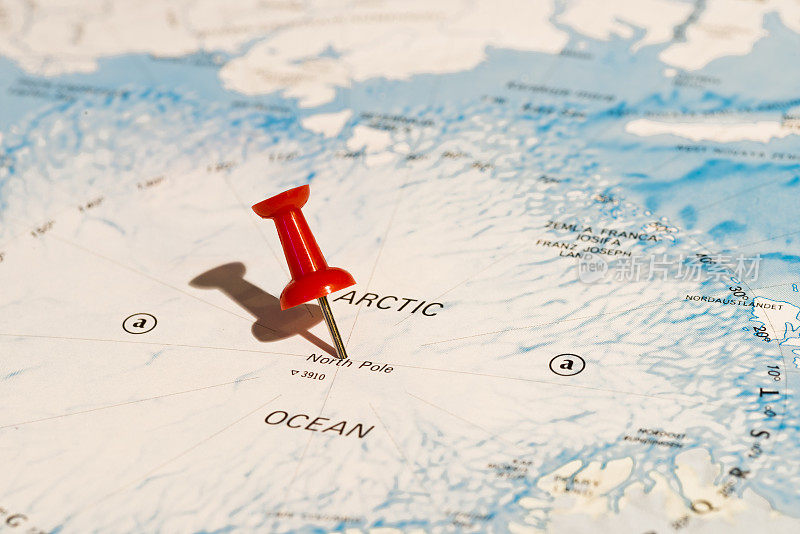 地图上的北极用红色图钉向左倾斜