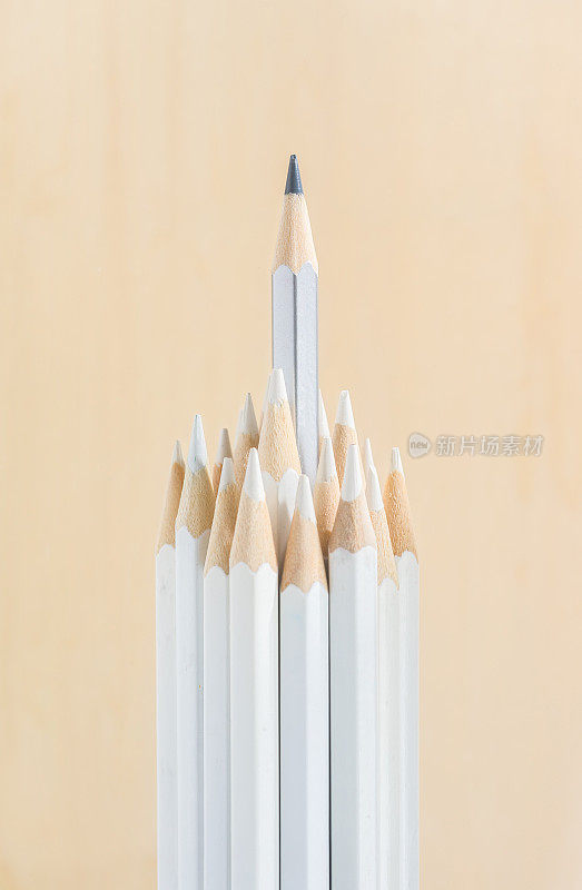 许多白色铅笔和一个彩色铅笔站在纸的背景