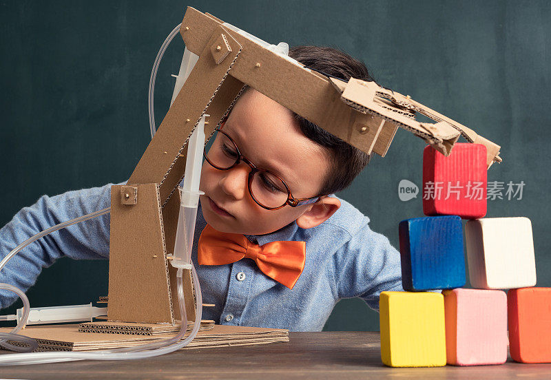 可爱的孩子发明了带有纸板的机器人手臂。