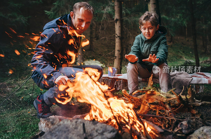 父亲和儿子在森林里生火