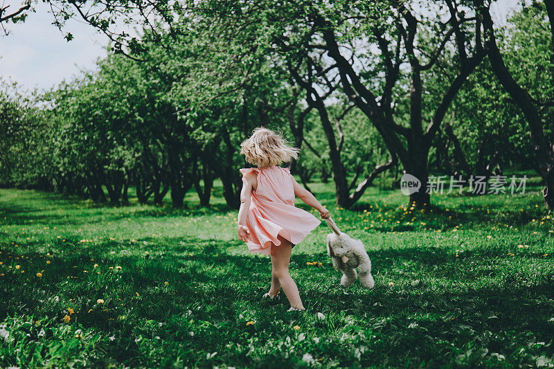 小女孩在草地上奔跑。