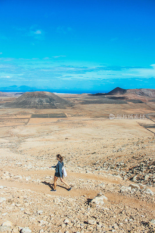 年轻女子徒步旅行与全景火山