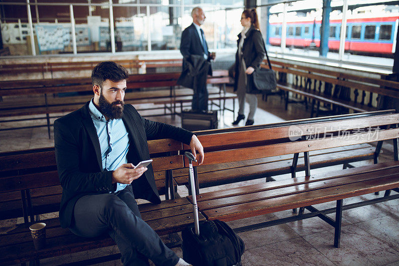 商人在火车站使用手机