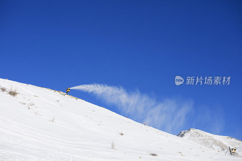 用雪枪造雪。滑雪坡人工下雪。滑雪场设有雪炮-造雪机。大自然美丽的冬天。山顶上刚下过雪。高山景观滑雪场。