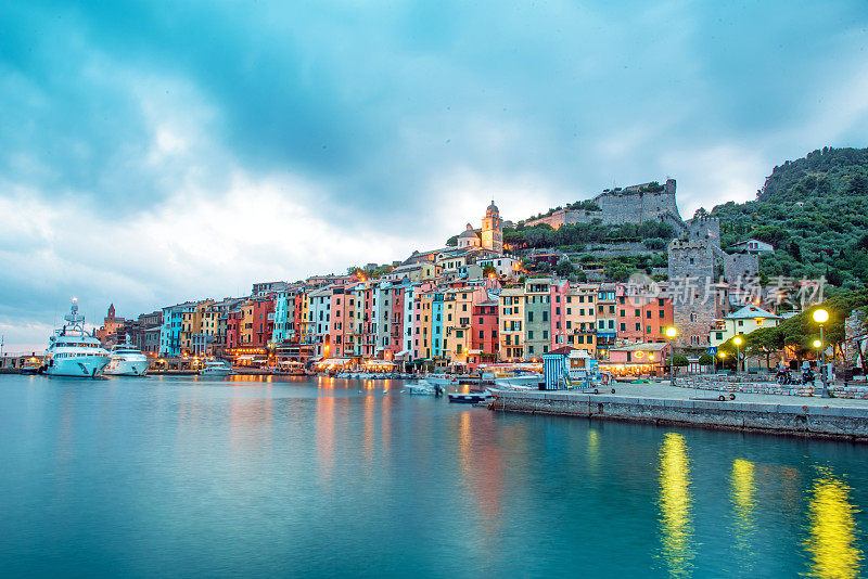 在意大利利古里亚的威尼托港，神秘的海港景观和五颜六色的船，在晚上的灯光下的灯笼