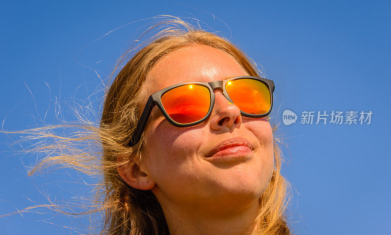 戴着太阳镜看天空的女模特