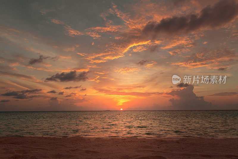 海滩上五颜六色的夕阳。多云的天空