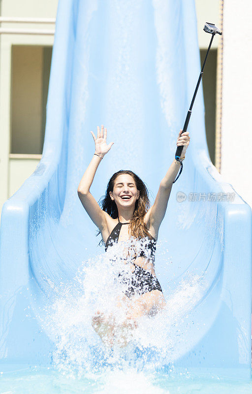 年轻女性在水上乐园滑水和自拍