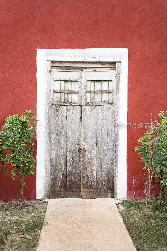 墨西哥尤卡坦:传统木门在充满活力的红墙