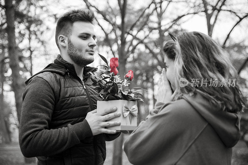 一对年轻夫妇带着礼物在公园里