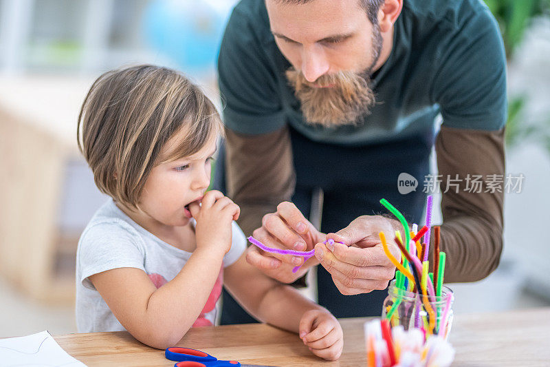 老师在教室里帮助女孩