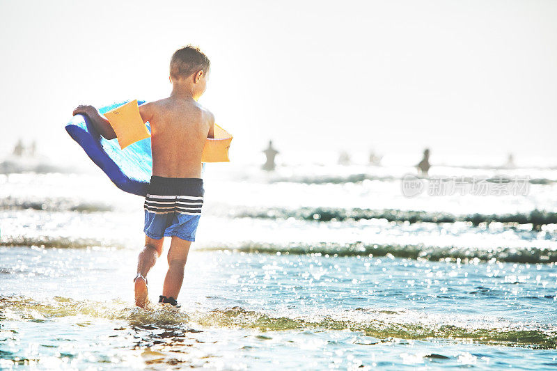 小男孩在海边玩滑板