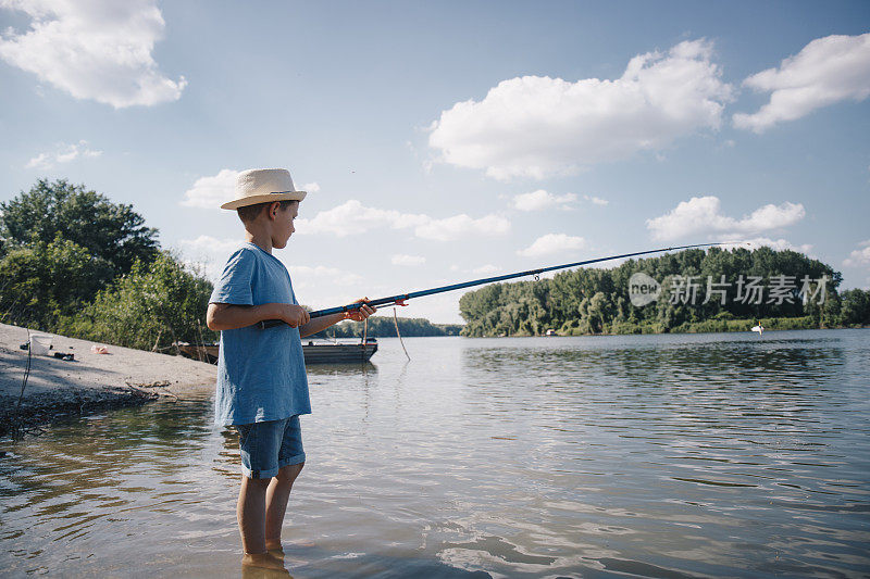 小男孩在河边钓鱼