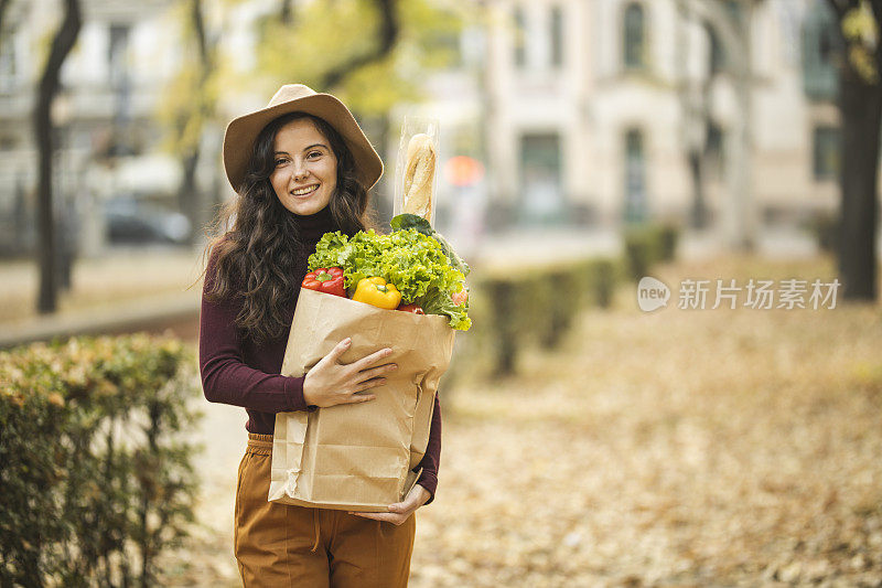 购物后拎着纸袋的女人的肖像