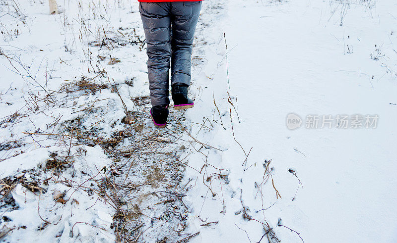 女人的腿在雪地上行走