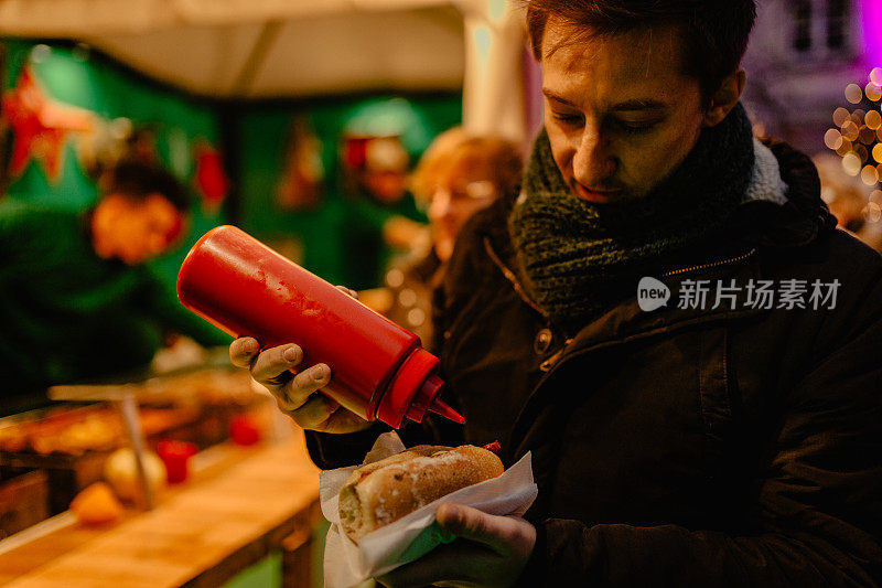 一名男子在德国圣诞市场上买热狗