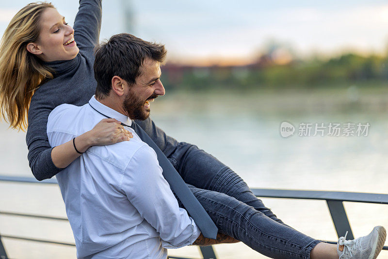 一个年轻人和他的女朋友在河边相拥