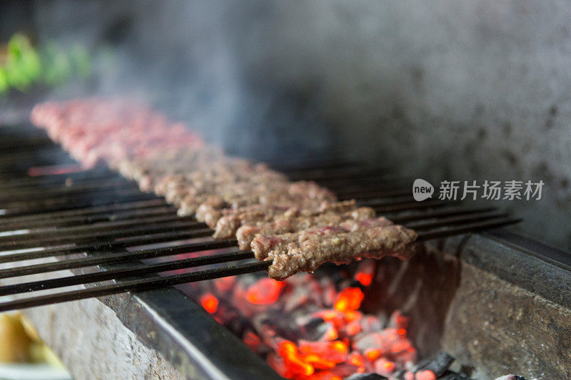 在传统风格的烧烤上烹饪阿达纳烤肉串-奥卡巴斯烧烤