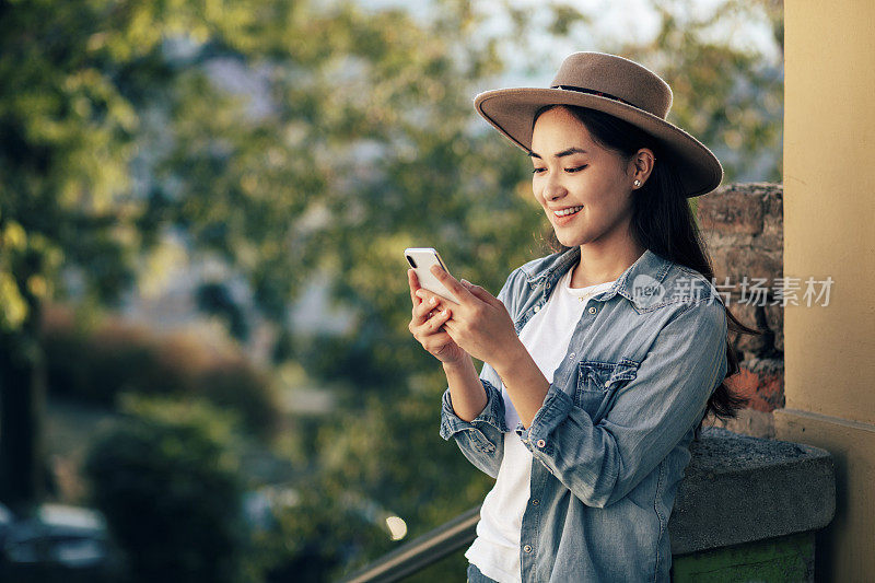 年轻的亚洲女人用手机发短信。