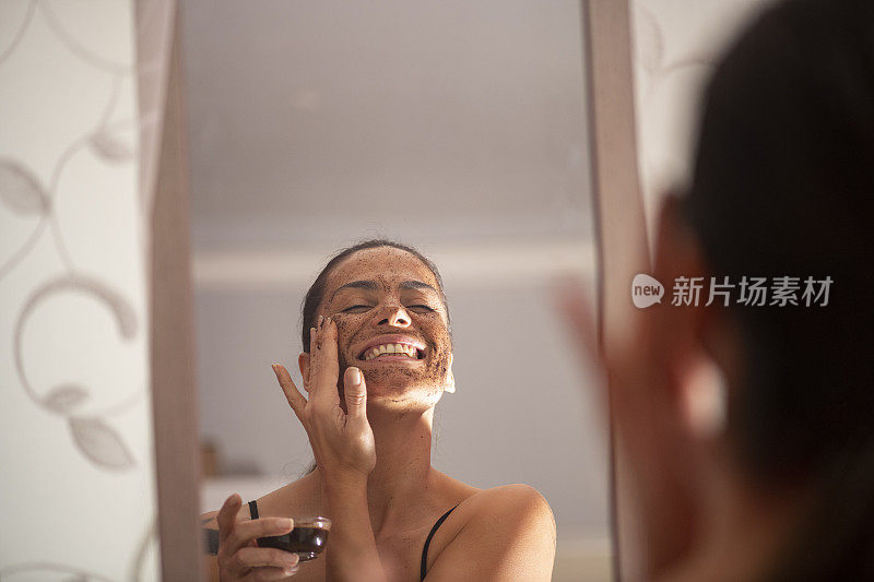 一个女人在镜子前做面膜