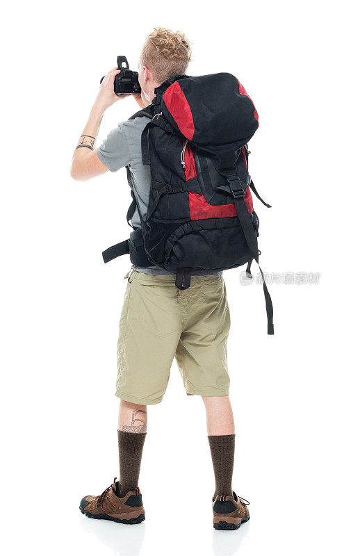 白人年轻男性摄影师徒步旅行在白色背景穿着徒步靴和拿着相机