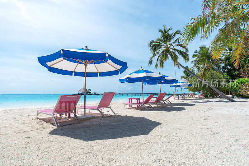 美丽的热带岛屿海滩配有躺椅和雨伞