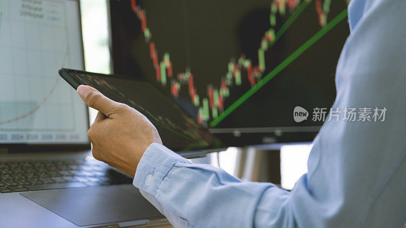 证券交易所交易员在现代化的交易办公室里，在显示器上处理图表。