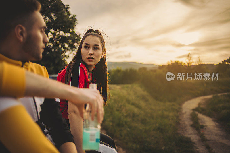 在夏日的一天和日落时分，一对愉快的夫妇在野餐时享受酒精