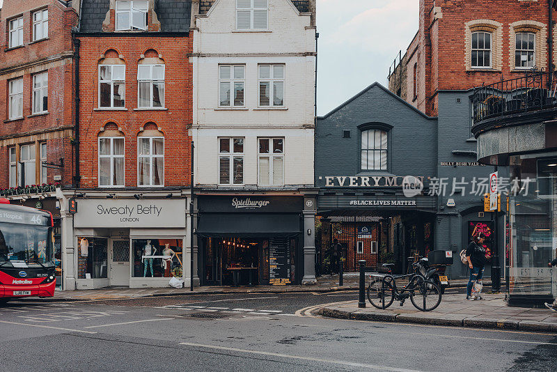 英国伦敦汉普斯特大街上的商店、餐馆和普通人电影院，选择性聚焦。