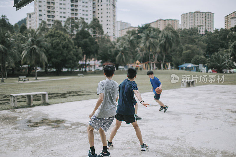 一群十几岁的亚裔中国男孩放学后在篮球场上打篮球