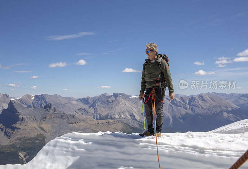 一位男性登山运动员到达了雪山的顶峰