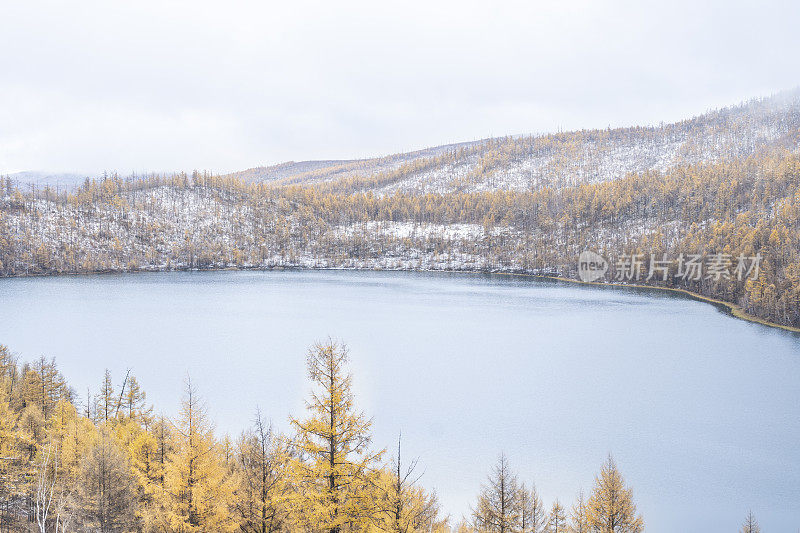 湖边山上的森林在秋天有雾有雪