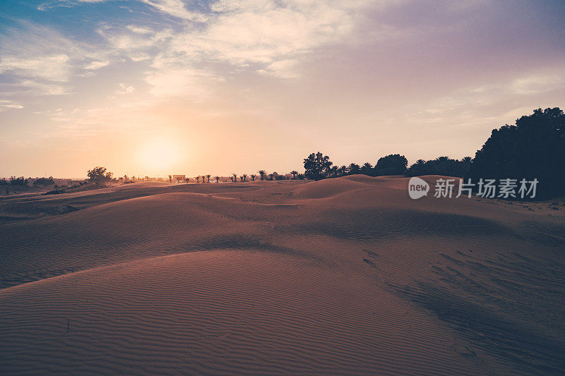 撒哈拉沙漠的日落。沙丘和多云的天空在Merzouga沙漠，摩洛哥。