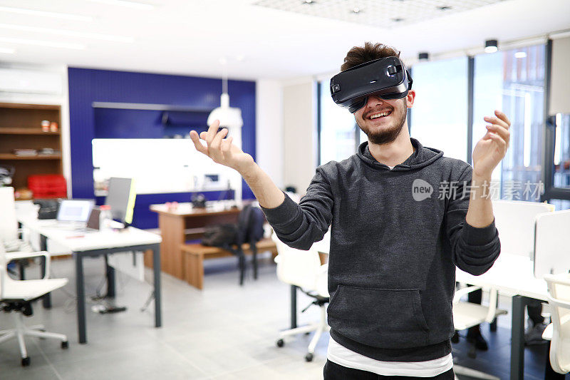 休闲着装的年轻人与VR眼镜在办公休息期间的乐趣