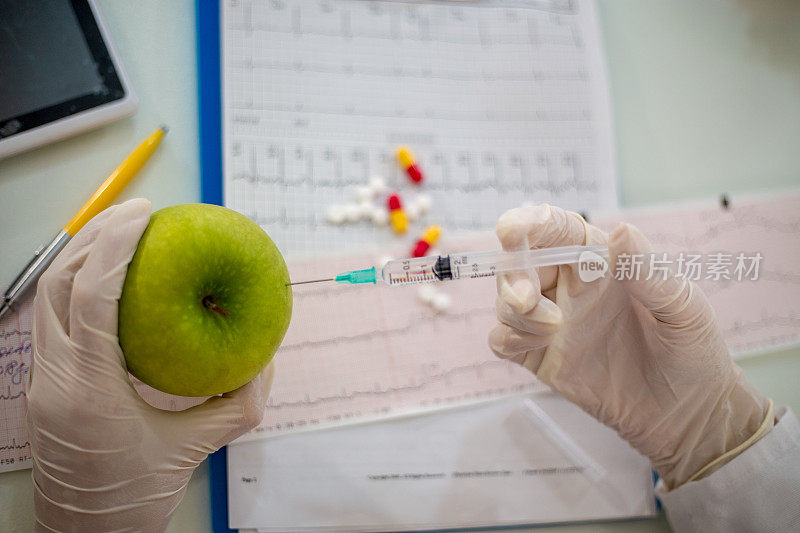 科学家医生用注射器注射苹果。拿着转基因水果的女化学家。转基因食品修改。