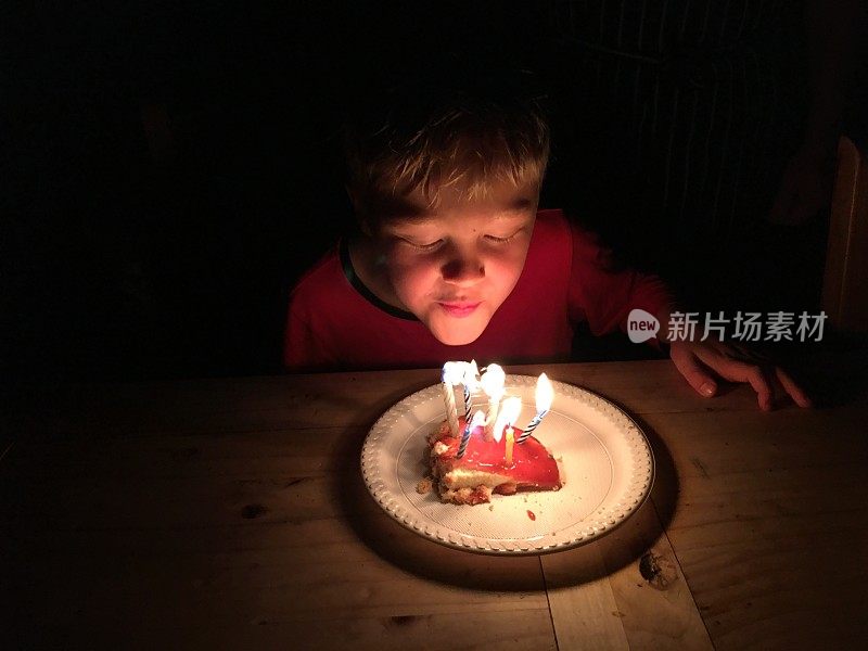 孩子吹灭生日蛋糕上的蜡烛
