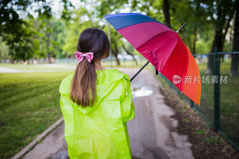 漂亮凉爽的女人带着五颜六色的雨伞在秋天的一天