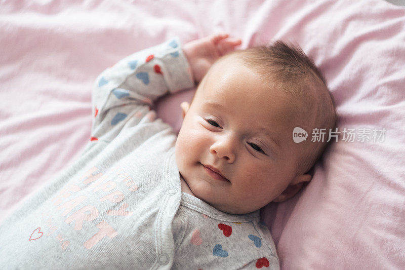 微笑的宝宝要睡觉了。三个月的小女孩玩着笑着。COVID-19大流行期间的新生儿。