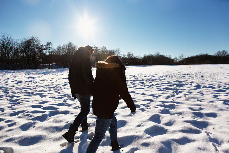 幸福的一对在雪地里一起散步