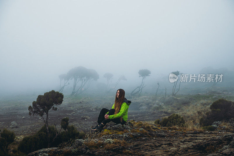 一个年轻的徒步旅行者在通往乞力马扎罗山路上风景优美的营地休息