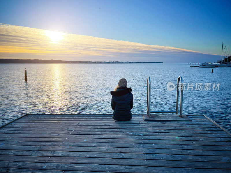孤独的女人在海边看日落